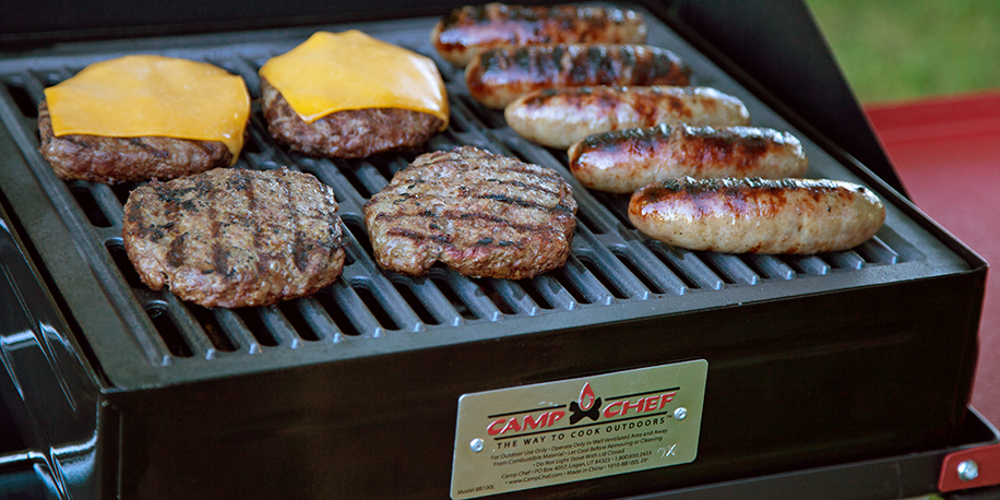 Burger patties and brats grilling on a BBQ Box