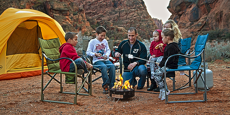 Family roasting marshmallows over propane fire pit