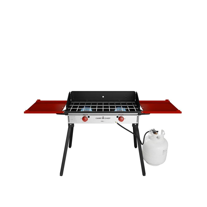 Load image into Gallery viewer, The Camp Chef PRO 14 is a portable propane gas grill with red side shelves, black legs, and an attached white propane tank, ideal for outdoor cooking and compatible with the Camp Chef cooking system. Shown on a white background.