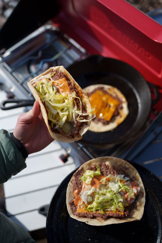 Big Mac smash tacos loaded with melted cheddar, shredded lettuce, and Big Mac sauce, cooked in cast iron on a Camp Chef Everest outdoors