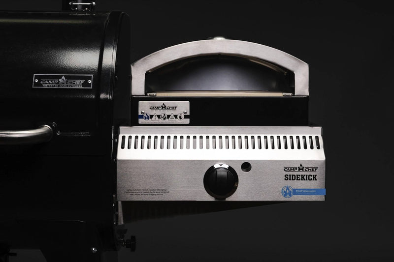 Load image into Gallery viewer, Close-up of a Camp Chef Sidekicks stainless steel grill accessory featuring a black lid, control knob, and grill vent set against a dark background.
