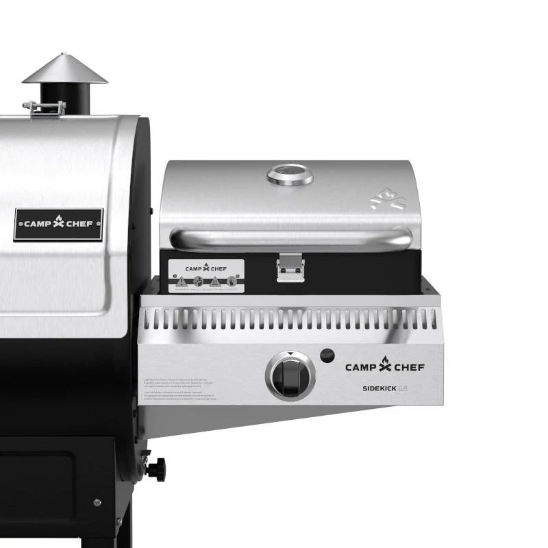 Load image into Gallery viewer, Close-up of a stainless steel Camp Chef BBQ Grill Boxes 14 outdoor grill attachment with cast iron grilling surface and closed lid, connected to a larger grill. Features include a handle, temperature gauge, control knob, and branded labels.
