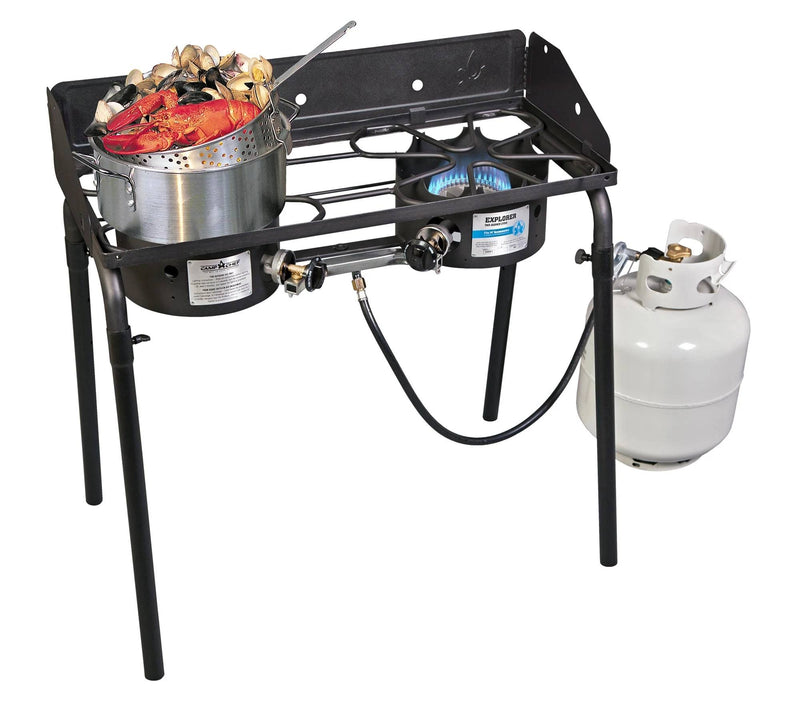 Load image into Gallery viewer, A Camp Chef Aluminum Cooker Pot boils seafood on one burner of a two-burner outdoor propane stove, with a blue flame under the other. An aluminum basket sits nearby, and a white propane tank connects underneath.
