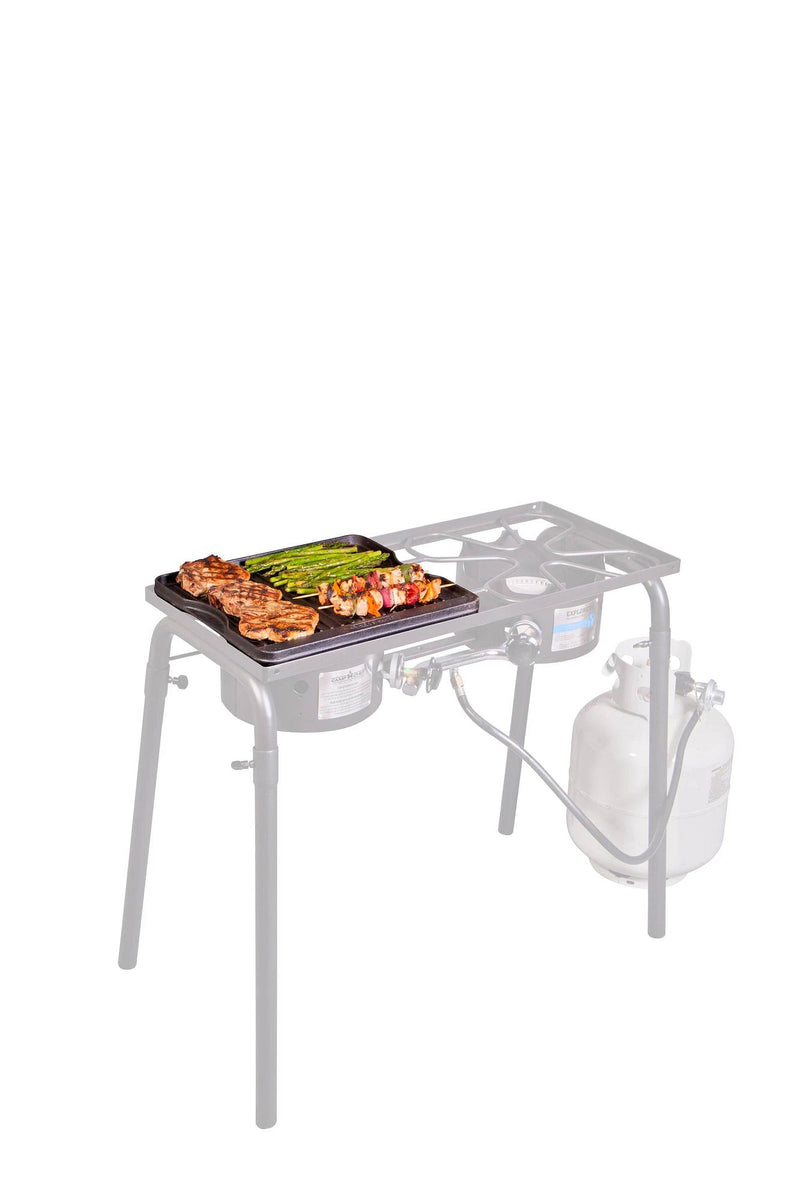 Load image into Gallery viewer, The Camp Chef Griddles 14 propane camp stove, equipped with metal legs, a side shelf, and a heat diffuser plate, is shown cooking chicken, asparagus, and veggie skewers on its pre-seasoned griddle with a connected propane tank.
