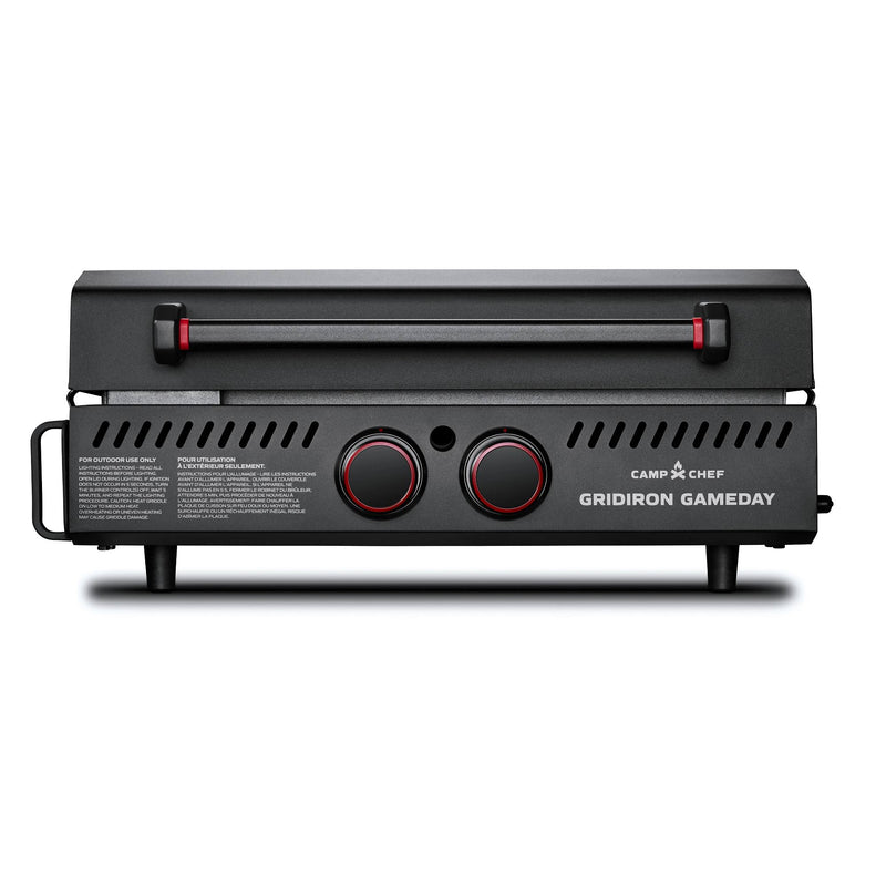 Load image into Gallery viewer, A black Camp Chef Gridiron Gameday portable grill with two red-accented knobs, a closed lid, side vents, and short legs is shown against a white background—perfect for outdoor cooking.

