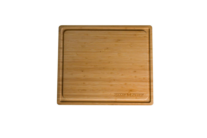 Load image into Gallery viewer, The Camp Chef Bamboo Cutting Board is square with a deep groove around the edge and features a "Camp Chef" engraving in the bottom right corner, pictured on a white background.
