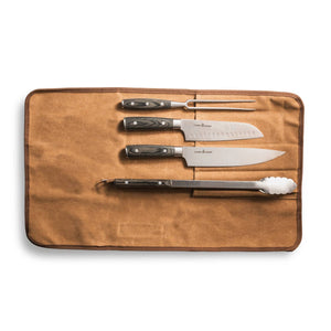 The Camp Chef 4 Piece Carving Set is shown in a tan canvas roll, featuring stainless steel knives, a carving fork, peeler, and metal tongs neatly organized against a white background.