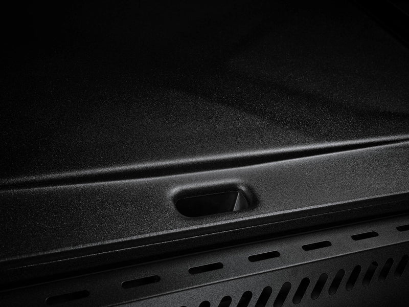 Load image into Gallery viewer, Close-up of the Camp Chef Gridiron 36's black, textured metal griddle surface with a rectangular cutout—engineered for even heating and easy clean-up. Low lighting highlights its design, ideal for outdoor cooking and hassle-free maintenance.
