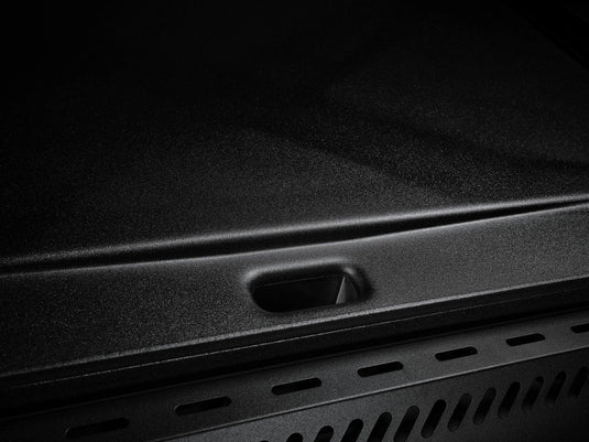 Close-up of the Camp Chef Gridiron 36's black, textured metal griddle surface with a rectangular cutout—engineered for even heating and easy clean-up. Low lighting highlights its design, ideal for outdoor cooking and hassle-free maintenance.