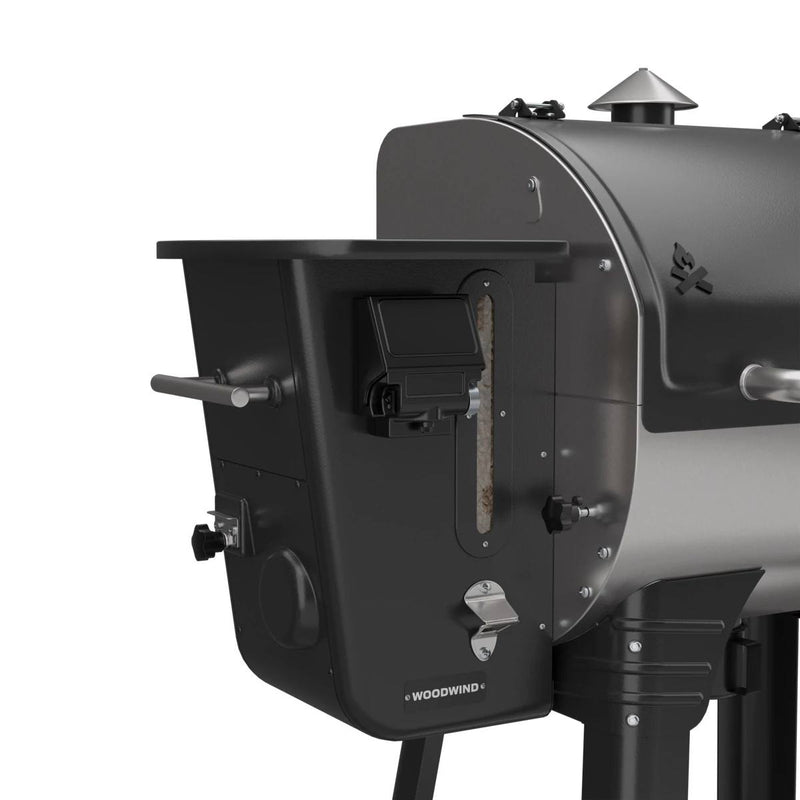 Load image into Gallery viewer, Close-up of the Camp Chef Woodwind 24 pellet grill in black and silver, showing the Woodwind logo, WIFI controller on the panel, hopper with pellet viewing window, and part of the grill chamber.
