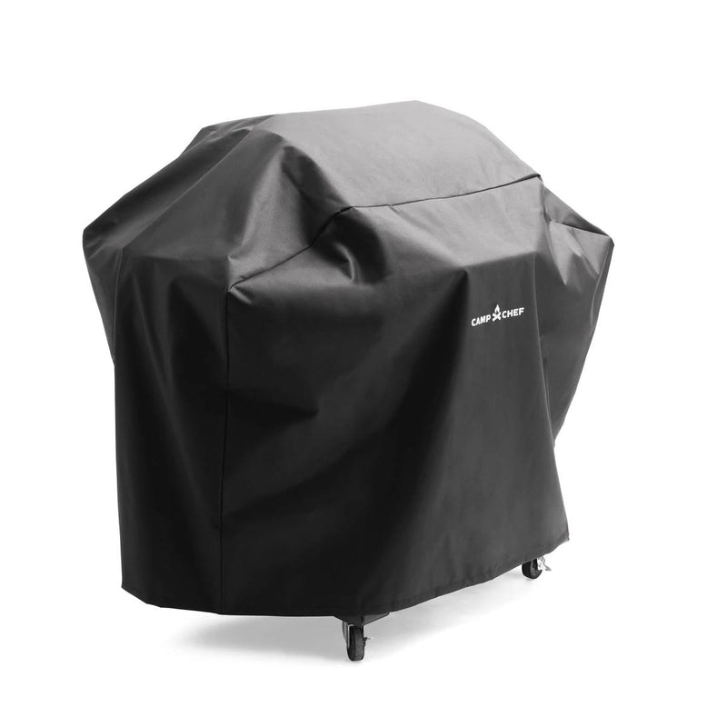 Load image into Gallery viewer, A black Camp Chef Woodwind Pro Cover fully conceals a grill, with the white Camp Chef logo displayed. Designed for Woodwind Pro pellet grills, it allows four wheels to remain visible at the bottom.
