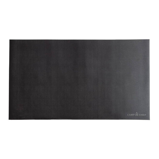 The Camp Chef Grill Mat 84 is a large, rectangular black grill mat with a small logo in the bottom right corner, designed for patio protection, shown on a plain white background.