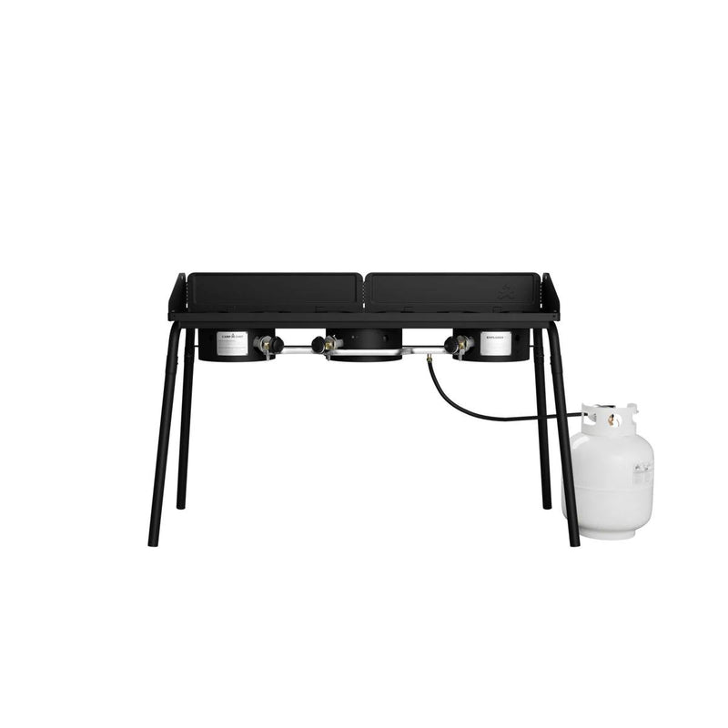 Load image into Gallery viewer, The Camp Chef Explorer is a black, two-burner outdoor propane gas stove with four legs and a white propane tank, ideal for outdoor cooking. Shown on a plain white background.
