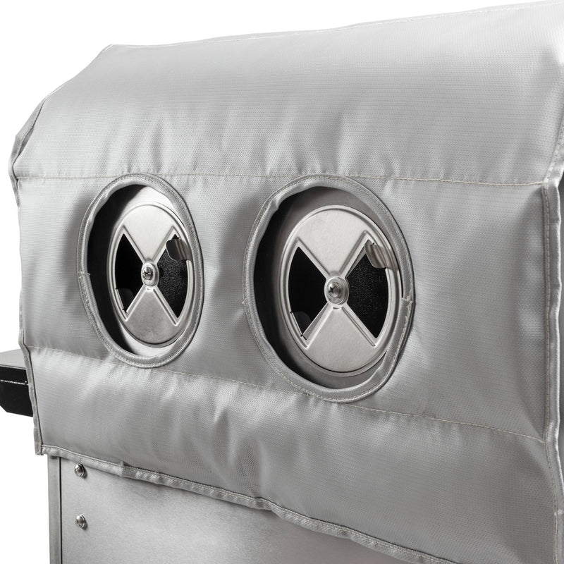 Load image into Gallery viewer, Close-up of a Camp Chef Woodwind Pro Blanket, a silver fire-resistant fiberglass cover for Woodwind grills, featuring two circular vents with adjustable cross-shaped openings.
