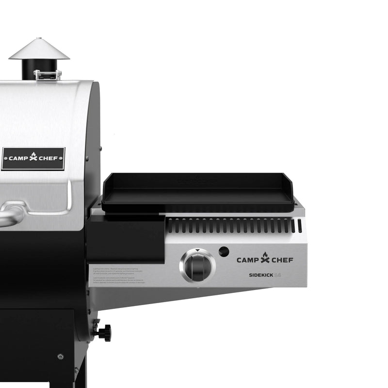 Load image into Gallery viewer, Close-up of a Camp Chef grill with the Camp Chef Sidekicks propane burner and flat top griddle, showing part of the main grill and the attached pellet grill accessory on the right.
