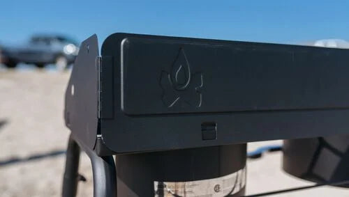 Black metal bracket with a logo on a blurred outdoor background