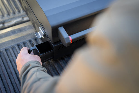 Person opening a truck bed cover with a hand