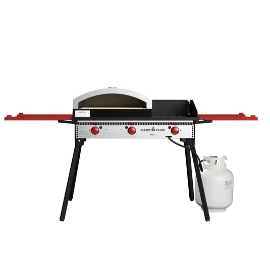 The Camp Chef Pizza Oven 16 - 2 Burner features a ceramic pizza stone, two red control knobs, a propane tank on the right, two red folding side shelves, and four sturdy black legs for outdoor cooking.