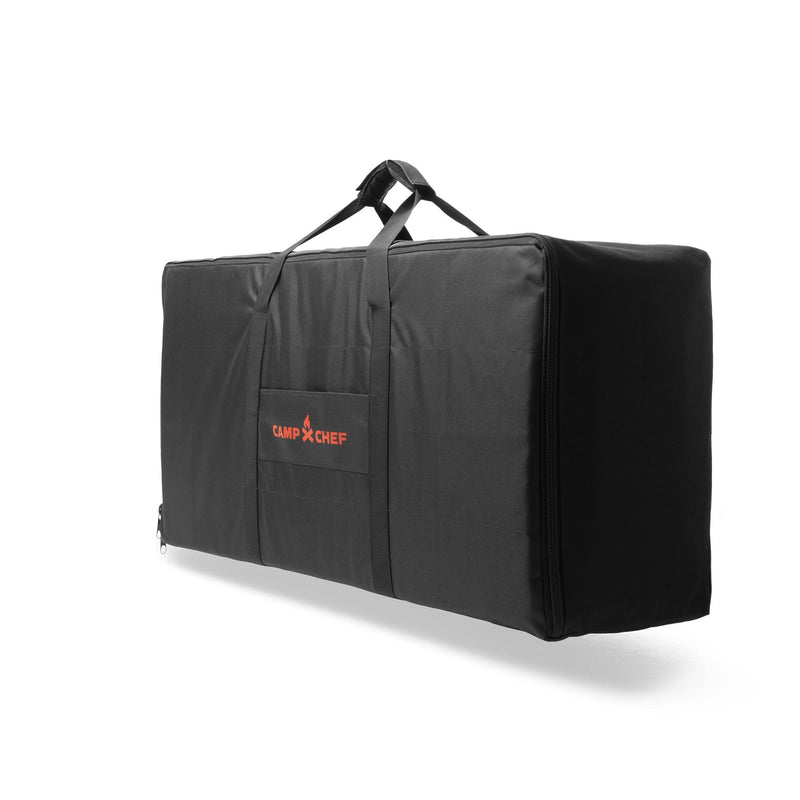 Load image into Gallery viewer, The Carry Bag 14 by Camp Chef is a large black rectangular bag with handles for 2-burner systems, featuring a red Camp Chef logo on the front pocket, shown against a plain white background.
