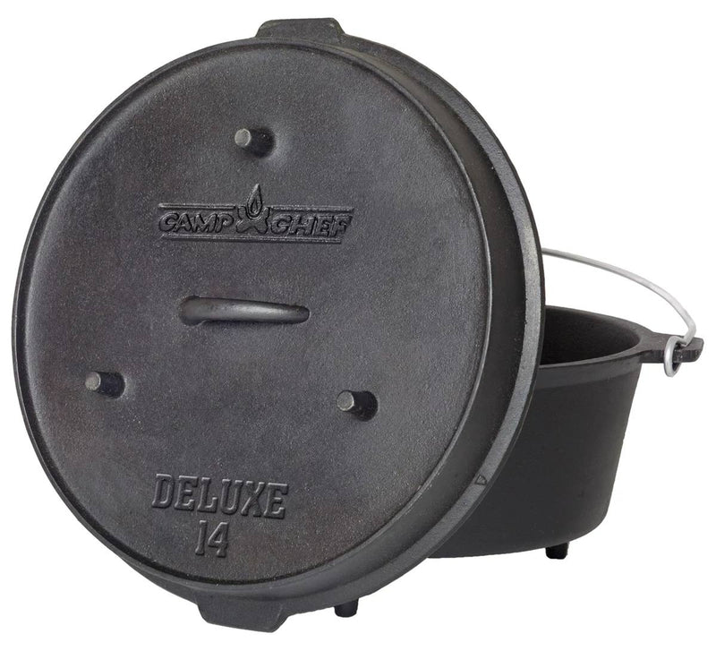 Load image into Gallery viewer, A black cast iron Deluxe Dutch Oven by Camp Chef features a handled lid labeled "Deluxe 14" and a metal handle, with the lid leaning against the pot.
