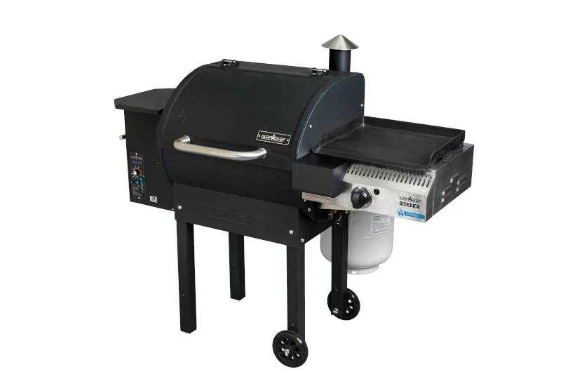 Load image into Gallery viewer, A black Camp Chef grill with covered cooking area, control panel, smokestack, and Sidekicks accessory on one side; mounted on four legs (two with wheels) and a propane tank beneath the griddle.
