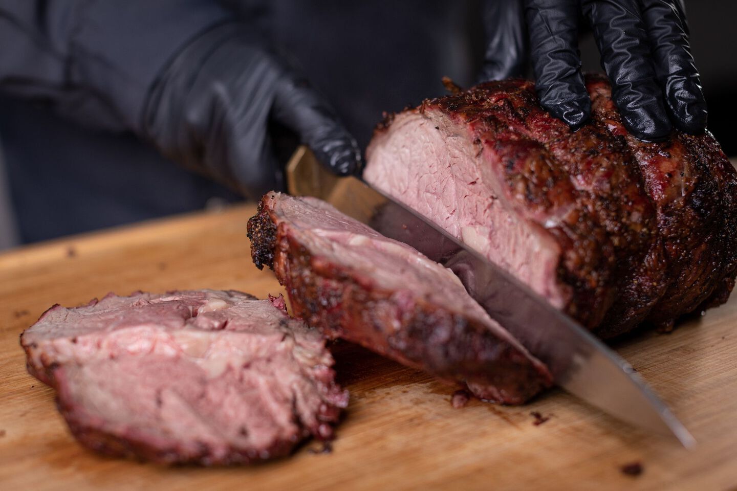 Chef de-boning and carving a portion of barbecued prime rib steak