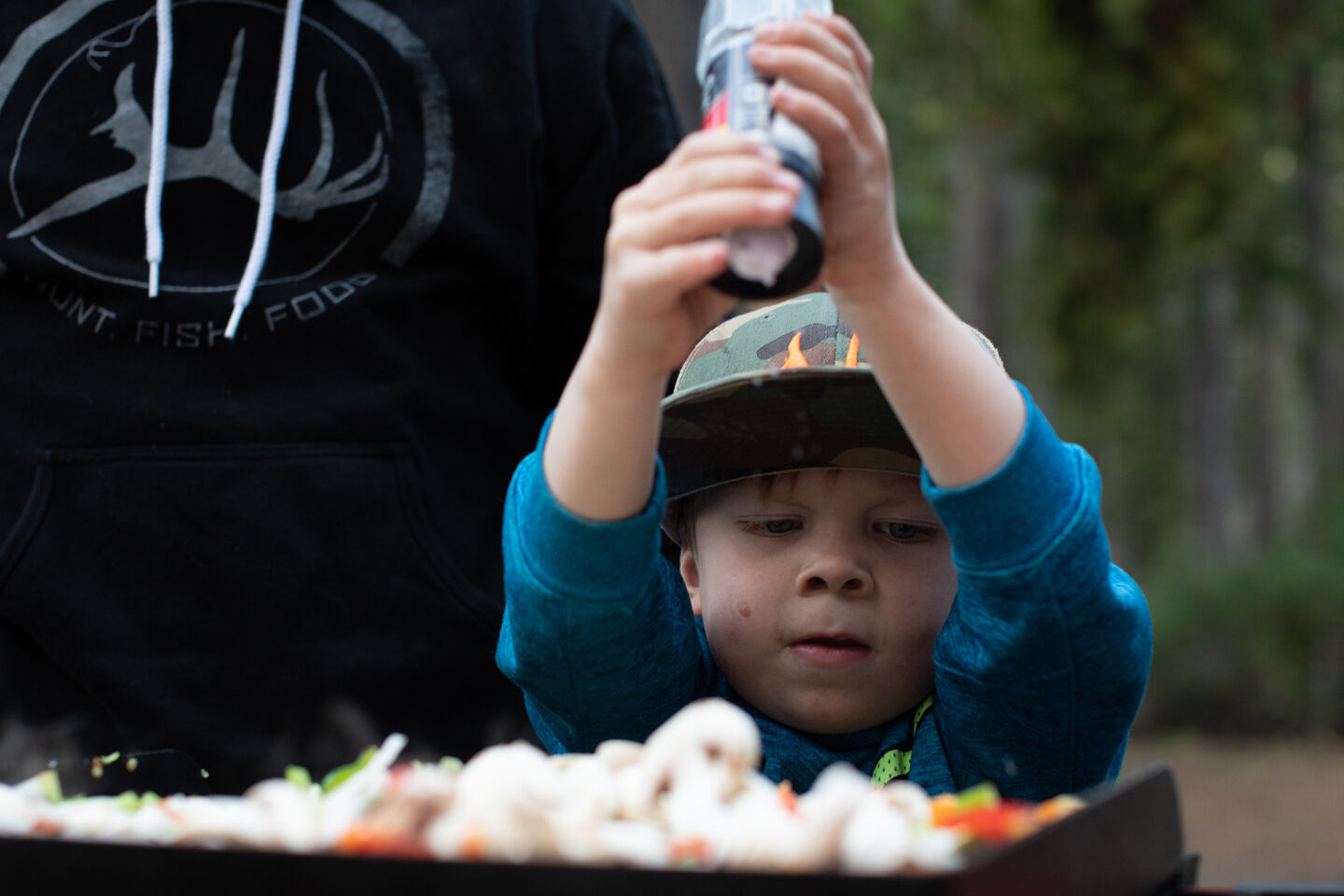 kid salting fajitas on a stove kid salting fajitas on a stove