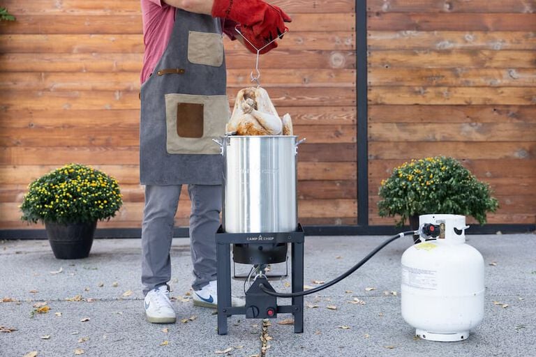 lowering a turkey into the fryer