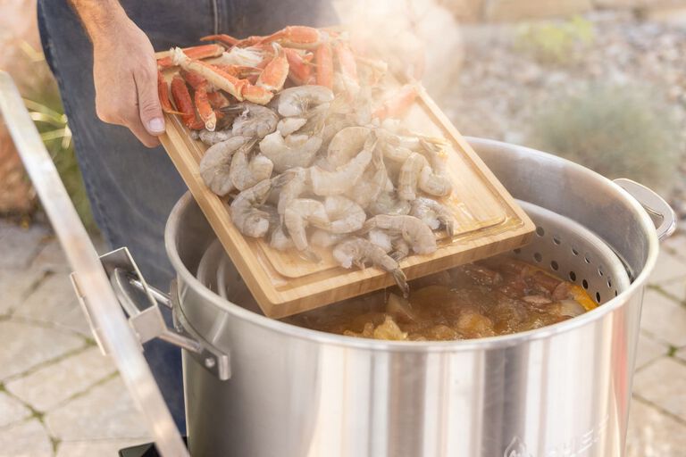 Adding in shrimp and crawfish to the boiler pot